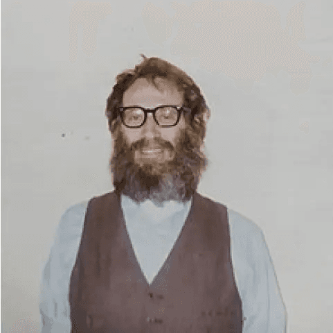 Portrait of Stephen Wiesner, seated, wearing glasses and a vest, photographed in 1988.