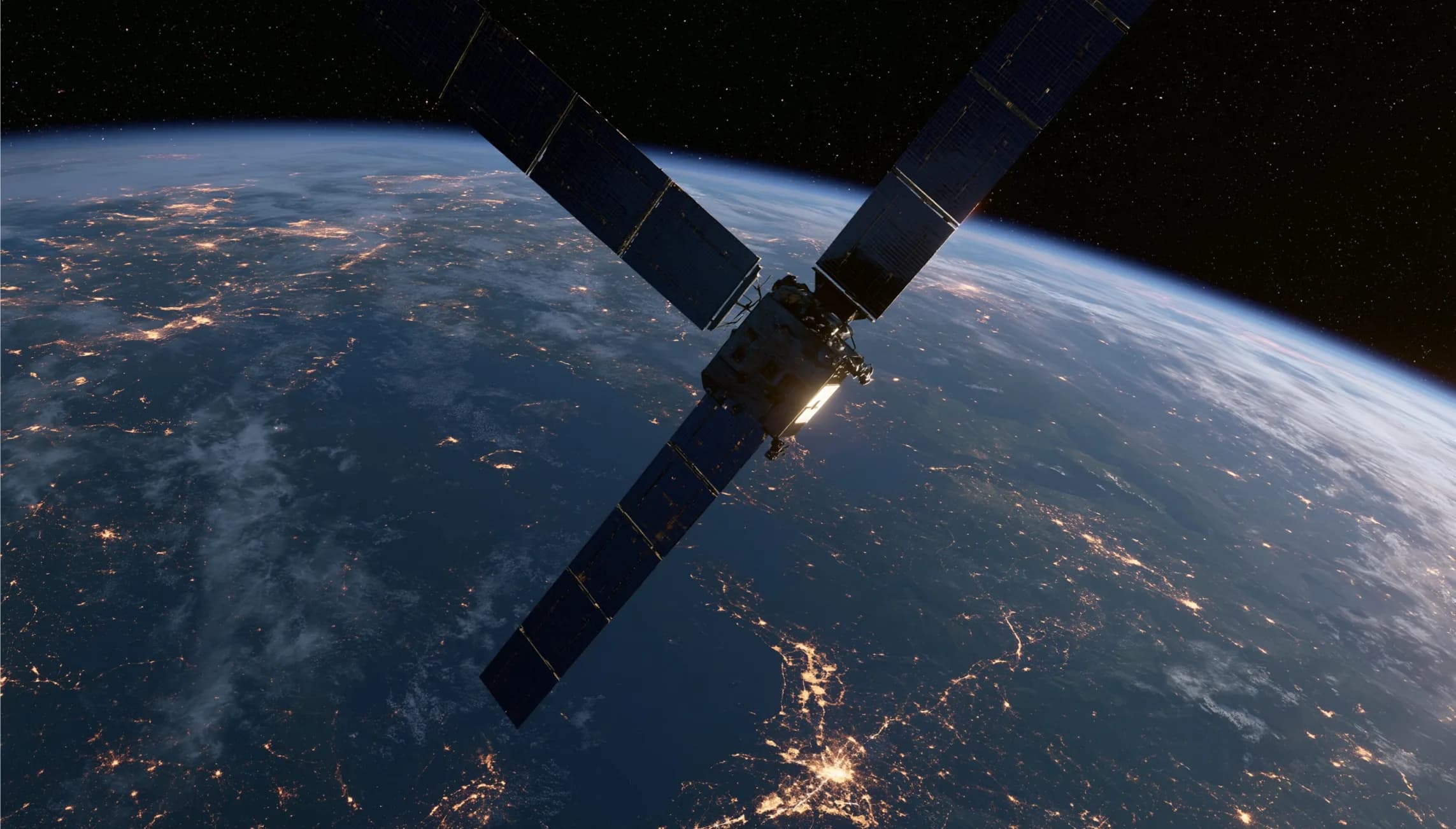 Satellite in orbit above Earth at night, city lights visible below